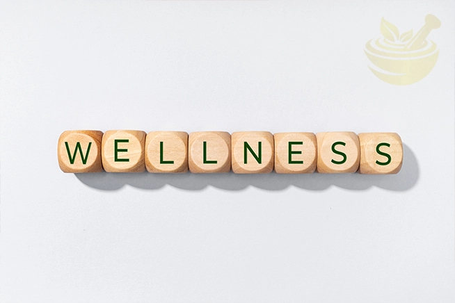 blocks spelling wellness on a neutral surface, symbolizing daily health and body balance, reflecting what are the benefits of black seed oil gummies