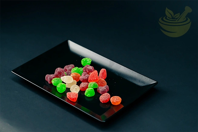 close-up of multicolored sugar-coated jelly gummies arranged on a black plate