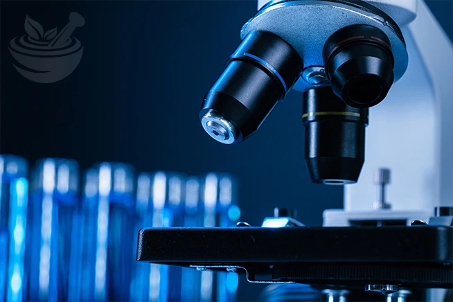 laboratory microscope with test tubes containing blue liquid, representing scientific research and clinical studies