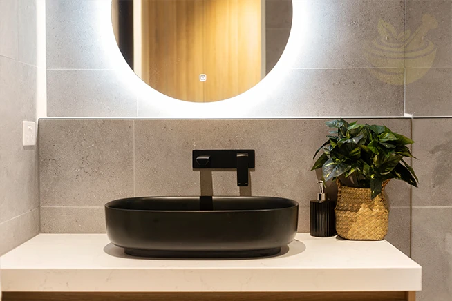 modern basin and round mirror in a contemporary bathroom, symbolizing winter skincare routines