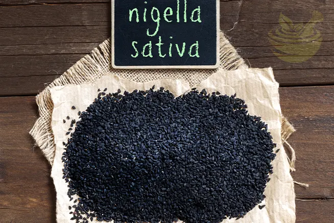 nigella sativa seeds with a small chalkboard, representing black cumin and its studied health properties